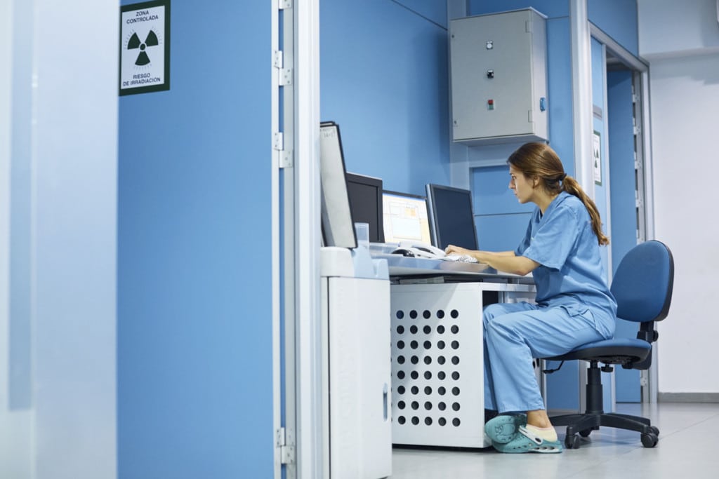 A doctor using a computer for work and the network is protected by HIPAA Cybersecurity Safe Harbor Laws